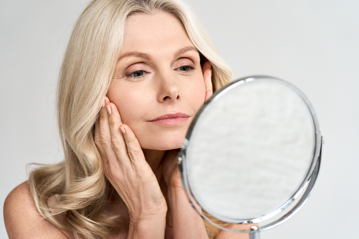 Elderly Woman in Mirror Touching Her Perfect Skin